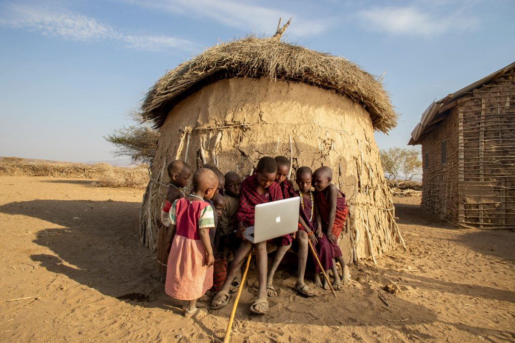 pexels photo 4314674 4314674 1 Group of African children in a Tanzanian village using a laptop outdoors, engaged in learning.